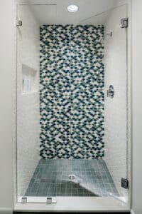 blue teal and white scalloped wall tile in a shower