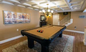 A refinished basement in rhode island with ceiling coffers and a pool table