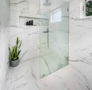 large format marble look tiles and a curbless shower with a linear drain